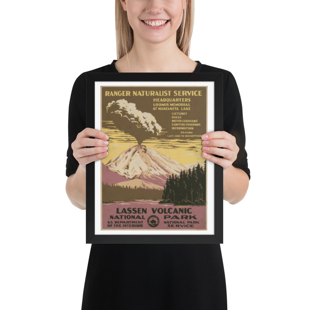 Person holding a framed poster of Lassen Volcanic National Park with a mountain and forest design.