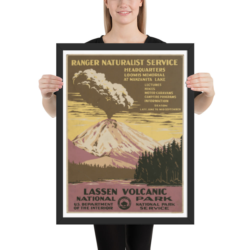 Person holding a framed poster of Lassen Volcanic National Park with mountain and forest design.