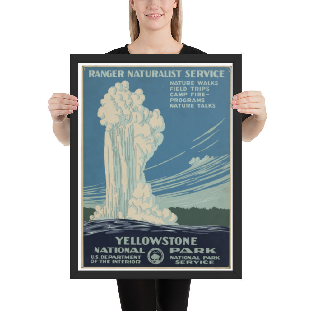 Person holding a framed Yellowstone National Park poster with a waterfall illustration.