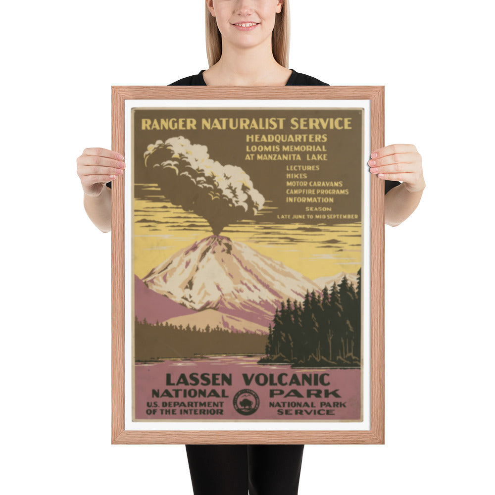 Person holding a framed poster of Lassen Volcanic National Park with a mountain and forest design.