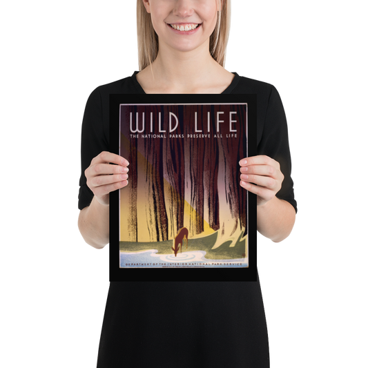 Person holding a framed poster with 'Wild Life' and nature design.